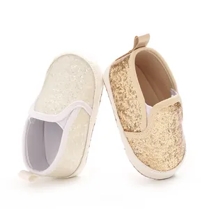 Detailed close-up of sparkling gold and silver glitter baby pre-walker shoes with soft soles
