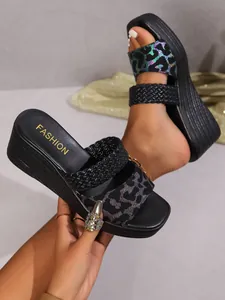 Close-up detail of stylish leopard print and black braided straps on comfortable wedge slippers