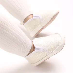 Close-up view of sparkling white glitter PU baby walking shoes featuring soft anti-slip soles