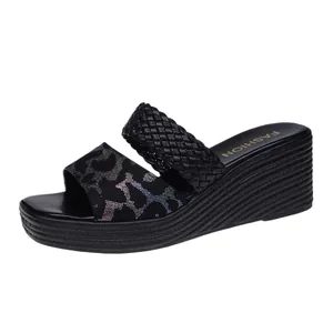 Detailed macro view of black wedge sandals with glitter leopard print and braided straps