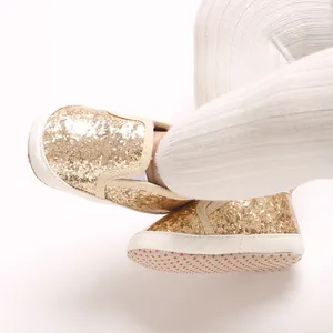 Close-up of gold glitter baby pre-walking shoes with soft anti-slip soles.