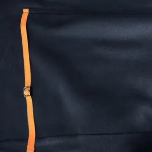 Detail view of navy hoodie arm pocket with orange adjustable strap and buckle