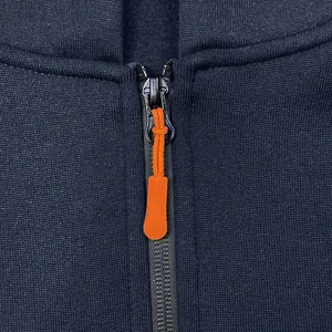 Close-up detail of the durable metal zipper and bright orange puller on navy hoodie