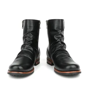 Detail view of men's black pleated boots with dual side zippers on white background.