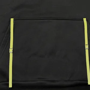 Detail of black hoodie featuring kangaroo pocket and lime green adjustable straps