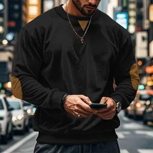 Close-up of men's black corduroy sweatshirt featuring brown elbow patches and casual crew neck