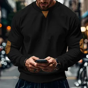 Detailed view of men's black corduroy long sleeve t-shirt with brown elbow patches.