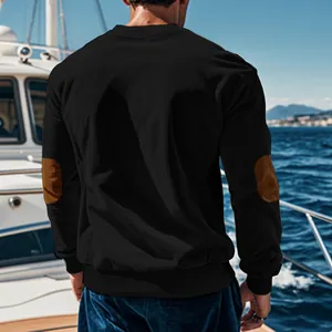Back view of a black long-sleeved men's t-shirt featuring brown elbow patches on a yacht.
