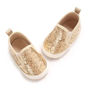 Detailed macro view of golden glitter infant soft sole loafers for walking babies