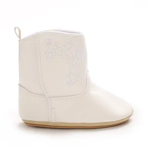 Side detail of white faux leather baby winter boots with elegant floral embroidery