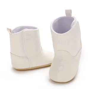 Detailed macro view of white faux leather baby boots featuring baby embroidery
