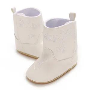 Detail of white infant winter boots with delicate heart and flower embroidery