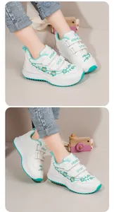 Dettaglio scarpe sportive bianche da bambina con ricamo floreale verde acqua e velcro