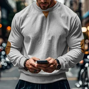 Close-up of men's grey corduroy sweatshirt showing elbow patches and textured fabric