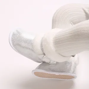 Close-up of silver glitter baby boots with white faux fur and non-slip soft sole