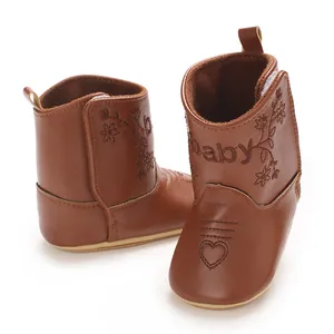 Macro view of brown winter baby boots featuring embroidered flower and heart details.