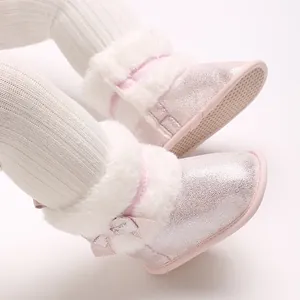 Detailed view of pink glitter winter baby shoes featuring white faux fur trim and soft soles
