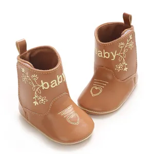Detailed view of brown baby winter boots with gold floral and heart embroidery