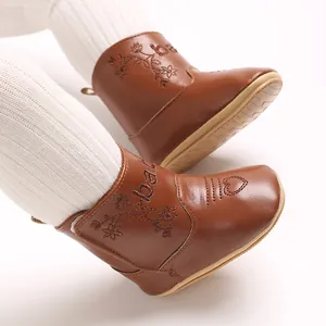 Detail of brown winter baby boots featuring floral embroidery and heart design.