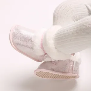 Detail view of pink glitter baby boots with soft white fur trim and bow accents