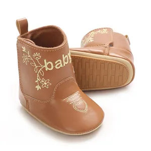 Close-up of brown baby boots with baby embroidery and soft slip-resistant sole details.