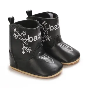 Detailed close-up of black baby boots with white flower and heart embroidery design