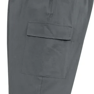 Detail shot of a large flap pocket on grey cotton linen casual trousers for men.