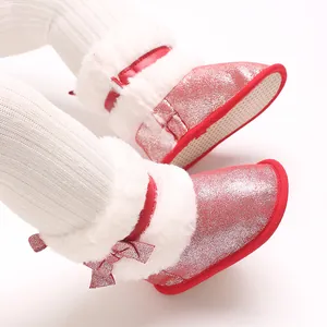 Macro view of red glitter baby winter boots with white faux fur trim and bow detail