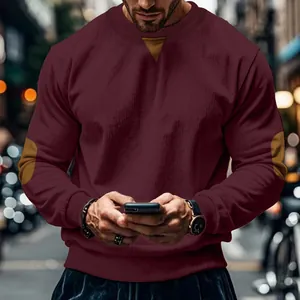 Close-up detail of corduroy texture and elbow patches on burgundy sweatshirt