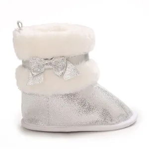 Detail view of silver baby winter boots with white faux fur and a glittery bow.