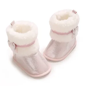 Close-up of pink glitter baby girl winter boots with white faux fur lining and bow detail