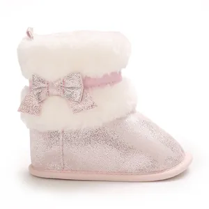 Macro shot of pink sparkly baby winter boots with thick white faux fur and a cute bow detail