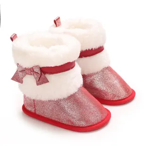 Close-up of red glitter baby girl winter boots with white faux fur and bow