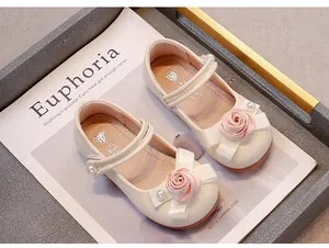 Nahaufnahme der cremefarbenen Mädchen-Prinzessin-Schuhe mit rosa Rose und Perlenband