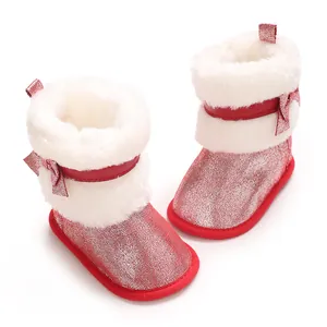 Close-up of red glitter baby winter boots with white faux fur and bow detail