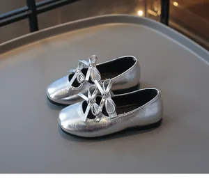 Detailansicht glänzend silberner quadratischer Kleinkindschuhe mit süßen Doppelbogen-Akzenten