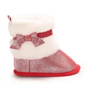 Detail view of baby girl winter boots in red glitter finish with white faux fur and bow