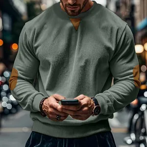 Macro detail of men's olive green corduroy sweatshirt with decorative elbow patches