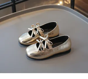 Detailansicht der goldenen Mädchenschuhe mit stilvollen Doppelbogendetails