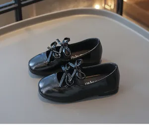Detailansicht glänzender schwarzer Mädchenschuhe mit eleganten Doppelschleifen