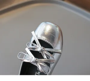 Detailaufnahme der silbernen Mary Jane Flats für Mädchen mit doppelter Schleife