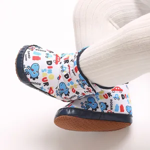 Nahaufnahme von Baby-Cartoon-Schneestiefeln mit Dinosaurier-Print und weichen Sohlen