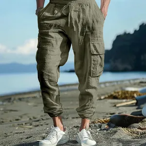 Detailed view of men's olive cargo pants with drawstring waist and side pockets on beach