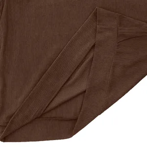 Detailed macro view showing the ribbed corduroy fabric texture and hem of brown sweatshirt