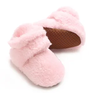 Detail von weichen rosa Korallenfleece-Babyschuhen mit rutschfesten Noppen