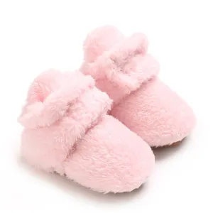 Nahaufnahme von weichen rosa Korallenvlies-Babyschuhen mit flauschiger Textur und Design