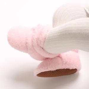 Detailansicht der rosa Korallenvlies-Babyschuhe mit weicher Textur und rutschfester Sohle.