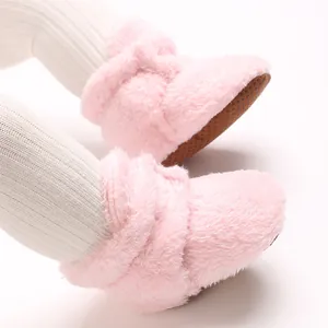 Nahaufnahme von weichen rosa Korallenvlies-Babyschuhen mit einer rutschfesten Sohle