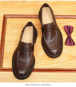 Top view detail of vintage brown horsehide leather penny loafers on wooden background