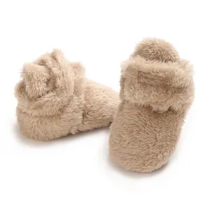 Detailansicht der weichen beigen Korallenvlies-Babyschuhe mit warmer Fellstruktur.
